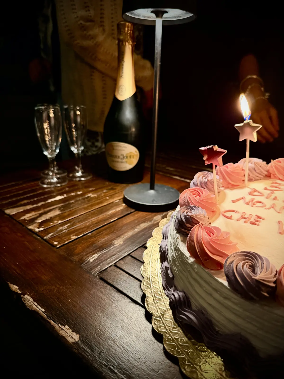Torta con le candeline, champagne e calici per un brindisi di compleanno