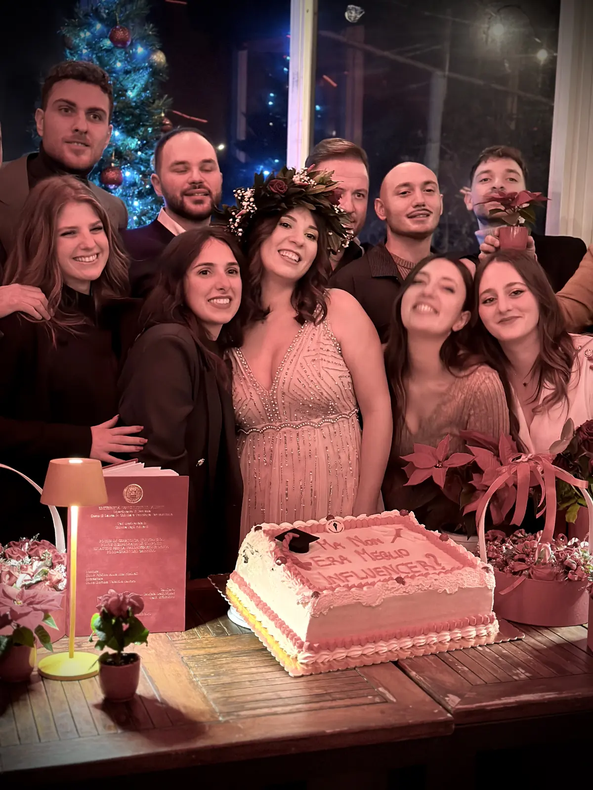 Una festa di laurea nella serra di Botanico: amici in posa dietro la torta
