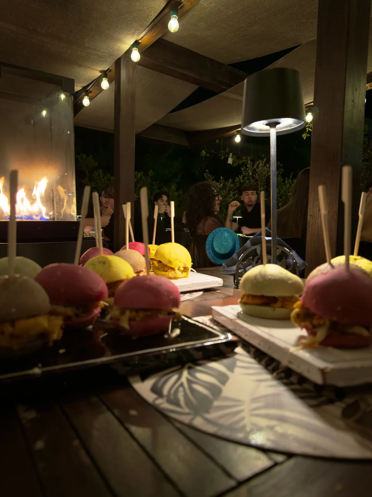 Mini bun colorati serviti al tavolo, con il fuoco della stufa sullo sfondo