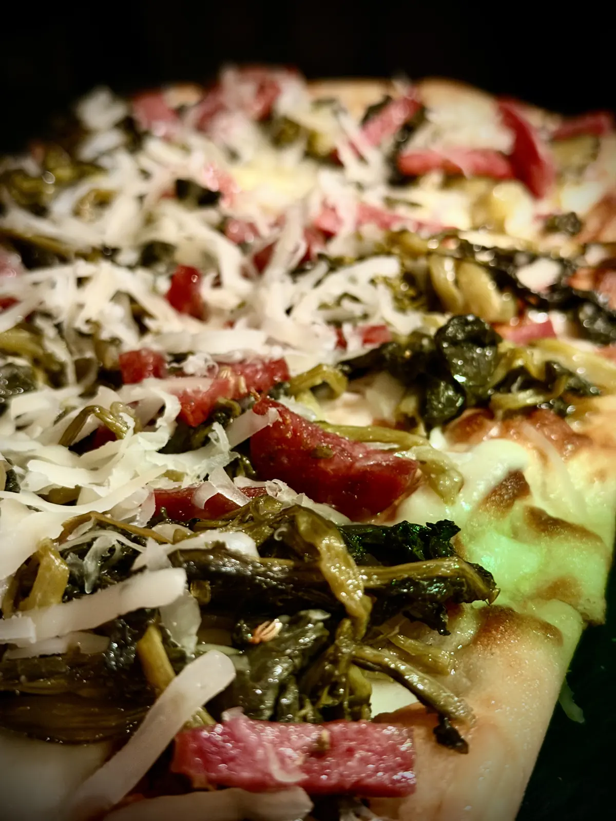 Una pinsa con verdure e scaglie di formaggio vista da vicino
