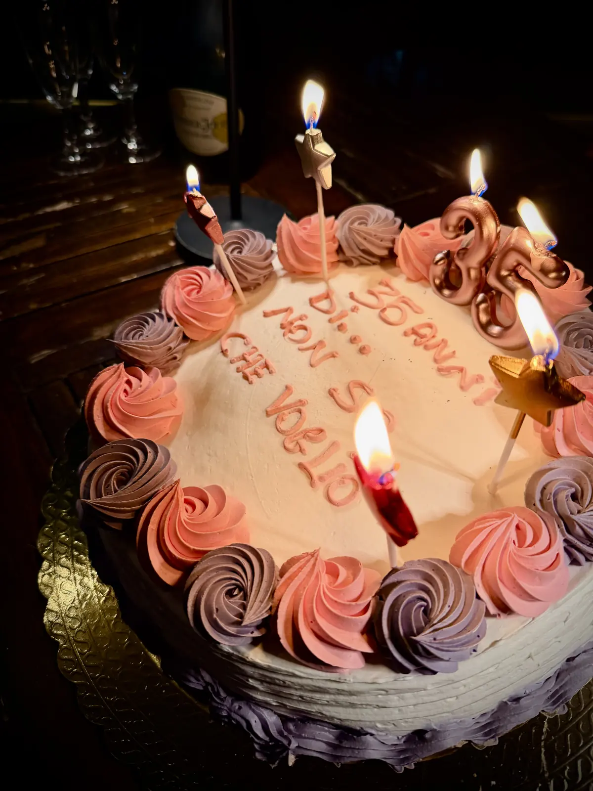 La torta di compleanno decorata con rose di panna e candeline